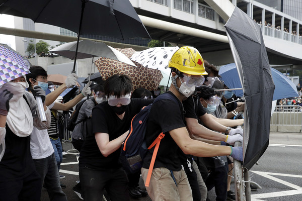 ▲香港12日二讀辯論《逃犯條例》，民眾戴口罩、眼罩，手持雨傘防備。（圖／達志影像／美聯社） 